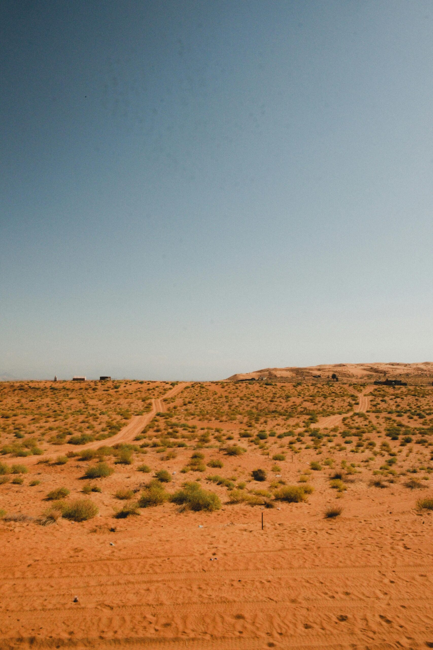 a landscape of mostly barren desert with a blue-grey horizon