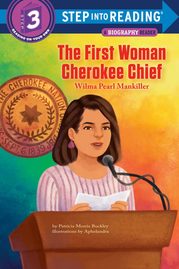 Wilma Mankiller, wearing a pink and white striped shirt, stands at a podium and reads from a pamphlet into the microphone