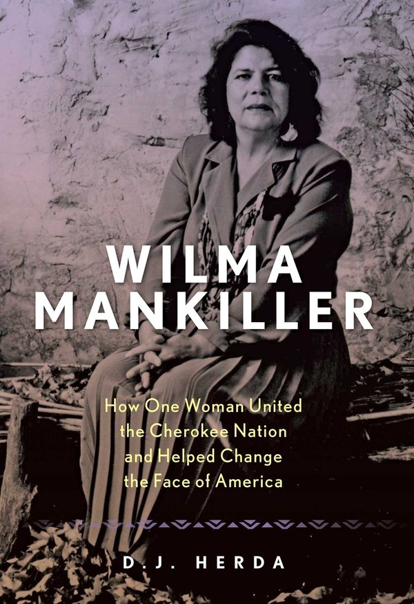 a black-and-white photo of Wilma Mankiller, wearing a long skirt and blazer with a Native beadwork necklace is the cover of the book